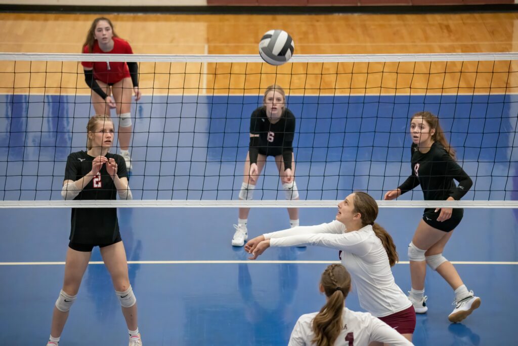 Female athletes engage in a competitive volleyball game indoors in Rochester, MN.